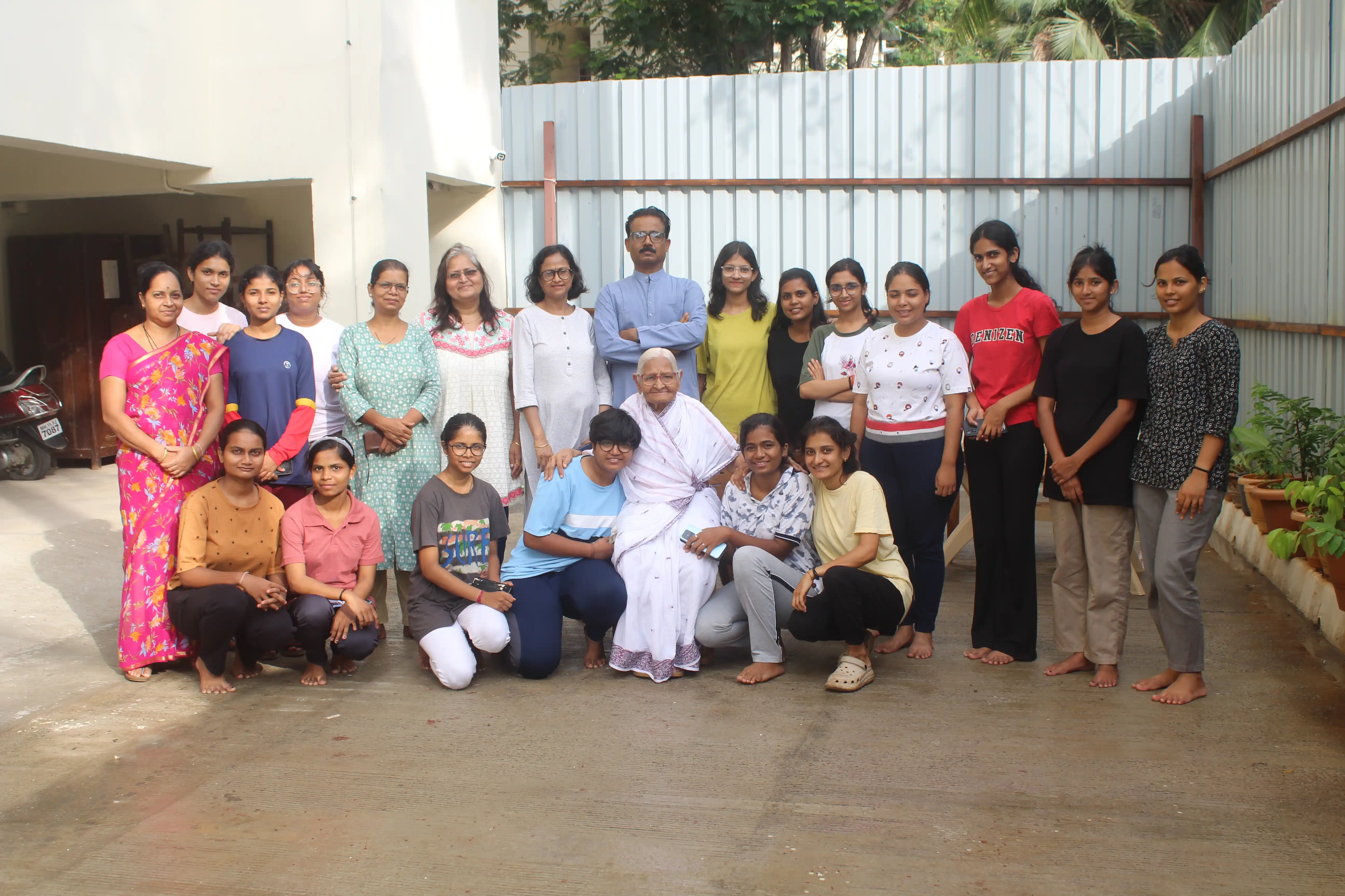 Large group of happy yoga practitioners posing together outdoors